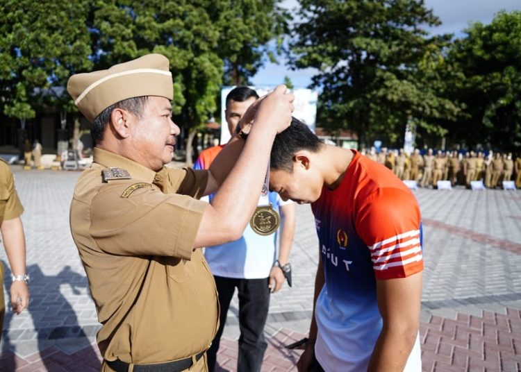 Bupati Garut, Rudy Gunawan, mengalungkan medali emas kepada Rama Teguh Adipratama, atlet asal Garut, yang menjadi Juara dalam ajang Kejurnas di Kabupaten Banyuwangi, Senin (8/8/2022).
