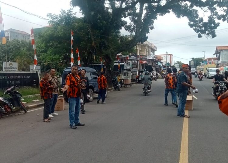 PAC.Pemuda Pancasila Pameungpeuk membagikan nasi pada tukang parkir, penguna jalan, pedagang di depan Alun-alun Pameungpeuk.